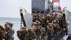 Personel Angkatan Laut Amerika Serikat menurunkan perlengkapan militer dari kendaraan amfibi LARC di pesisir Aroyo Puerto dalam latihan logistik maritim.