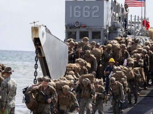 Personel Angkatan Laut Amerika Serikat menurunkan perlengkapan militer dari kendaraan amfibi LARC di pesisir Aroyo Puerto dalam latihan logistik maritim.
